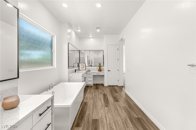 bathroom featuring vanity, hardwood / wood-style floors, and a tub