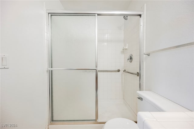 bathroom featuring toilet and an enclosed shower