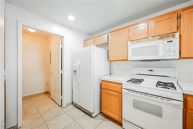 kitchen with white appliances, light tile patterned flooring, and tile countertops