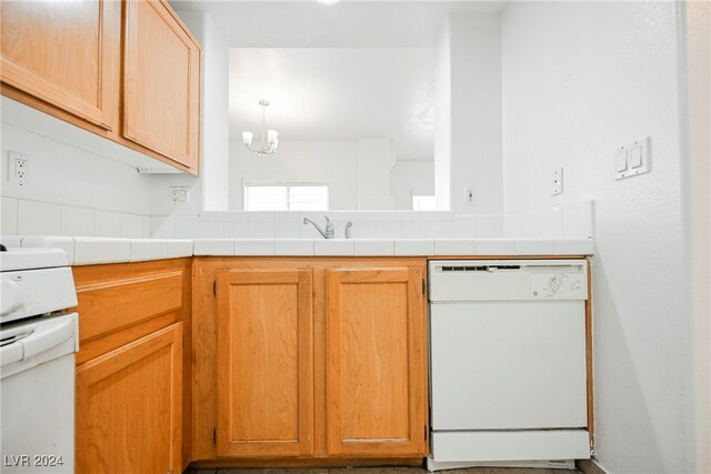 kitchen featuring pendant lighting, a notable chandelier, tile counters, and white appliances