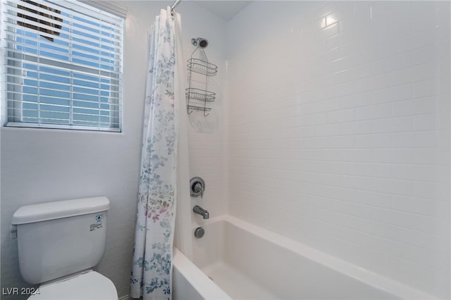 bathroom with shower / tub combo with curtain, a healthy amount of sunlight, and toilet