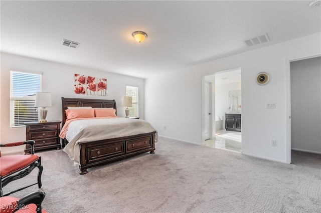 carpeted bedroom featuring ensuite bath