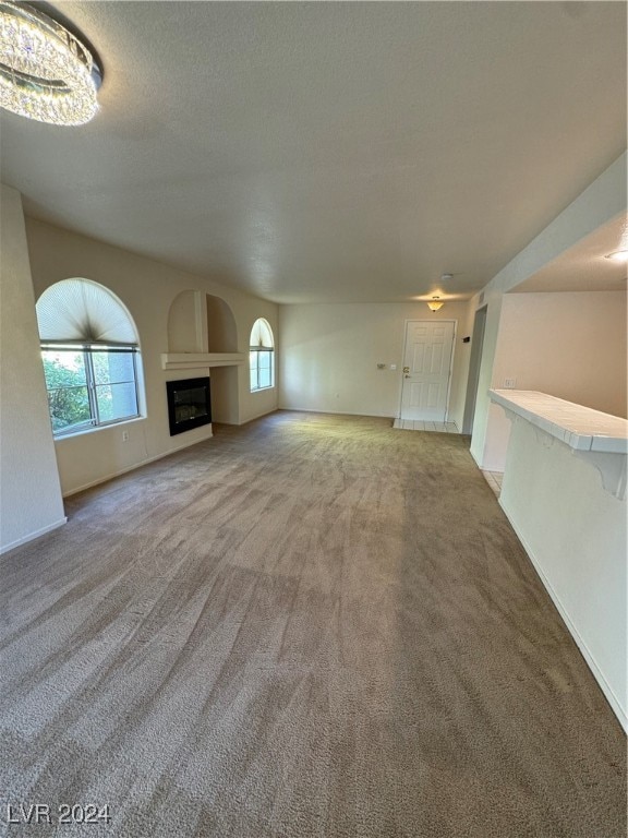 unfurnished living room with a textured ceiling and carpet