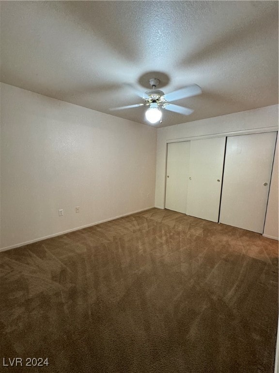 unfurnished bedroom featuring carpet floors, a textured ceiling, ceiling fan, and a closet