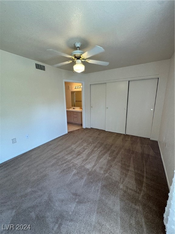 unfurnished bedroom featuring a closet, ceiling fan, carpet flooring, and a textured ceiling