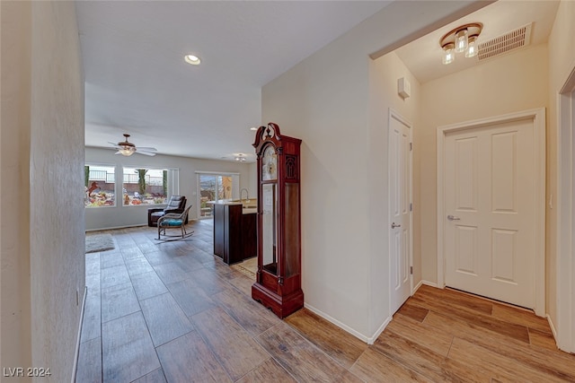 corridor featuring light hardwood / wood-style floors and sink