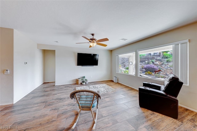 living room featuring light hardwood / wood-style flooring and ceiling fan