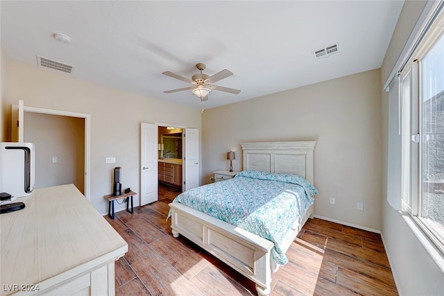 bedroom featuring wood-type flooring, connected bathroom, and ceiling fan