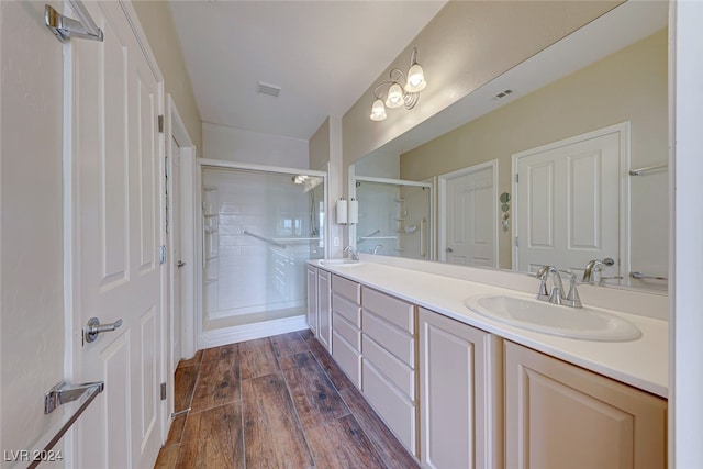 bathroom with wood-type flooring, vanity, and an enclosed shower