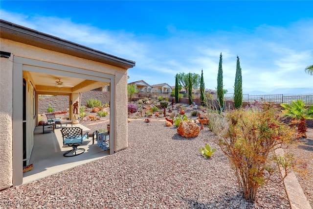 view of yard with ceiling fan and a patio area