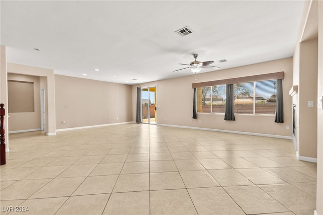 tiled empty room featuring ceiling fan