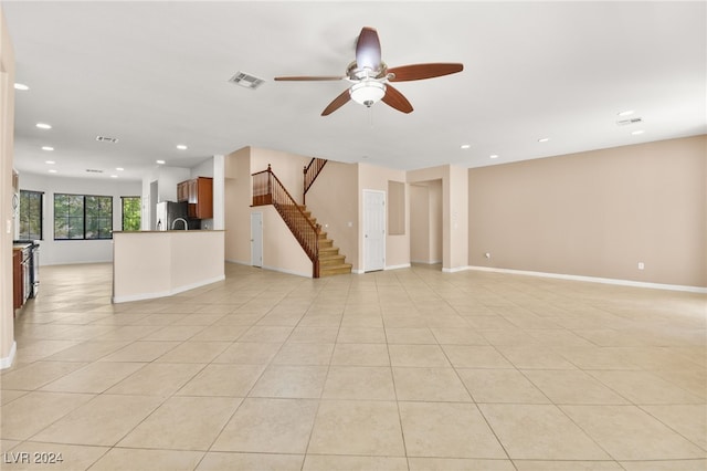 tiled empty room featuring ceiling fan