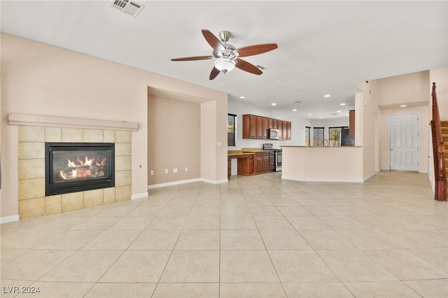 unfurnished living room with light tile patterned floors, a fireplace, and ceiling fan