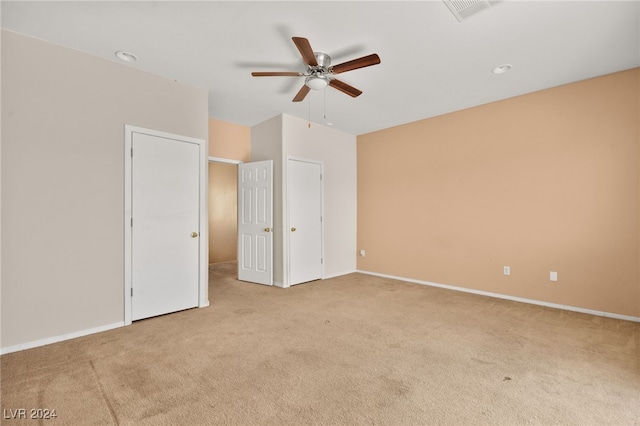 unfurnished bedroom featuring ceiling fan and light colored carpet