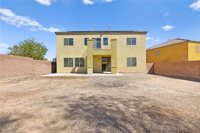 back of house with a balcony and a patio