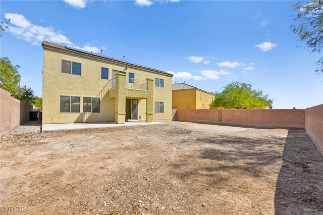 rear view of house featuring a patio and a balcony