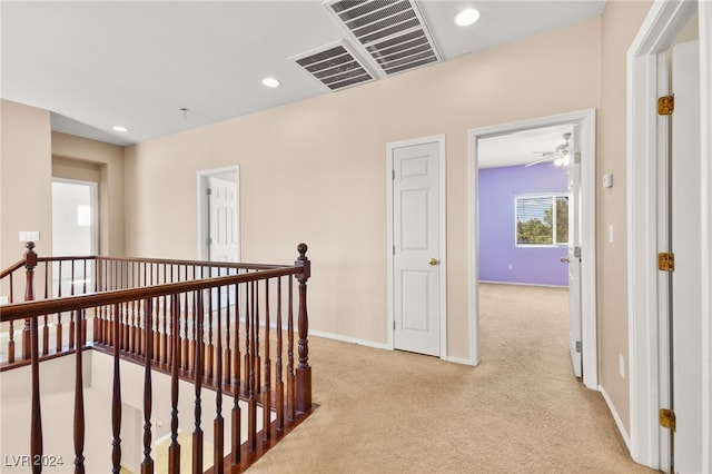 hall featuring light colored carpet