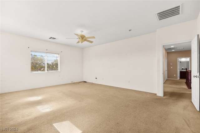 unfurnished room featuring ceiling fan and light carpet