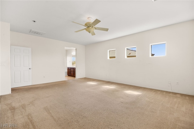 spare room with ceiling fan and light colored carpet