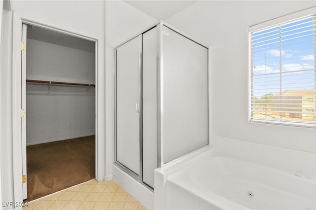 bathroom featuring a wealth of natural light and separate shower and tub