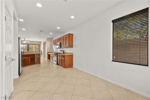 kitchen featuring ceiling fan, stainless steel appliances, and light tile patterned floors