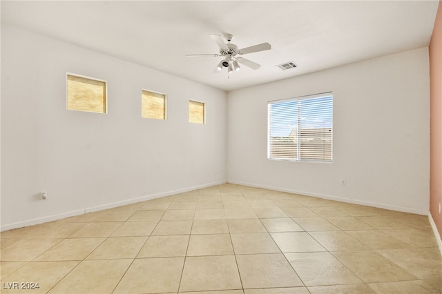 tiled spare room with ceiling fan