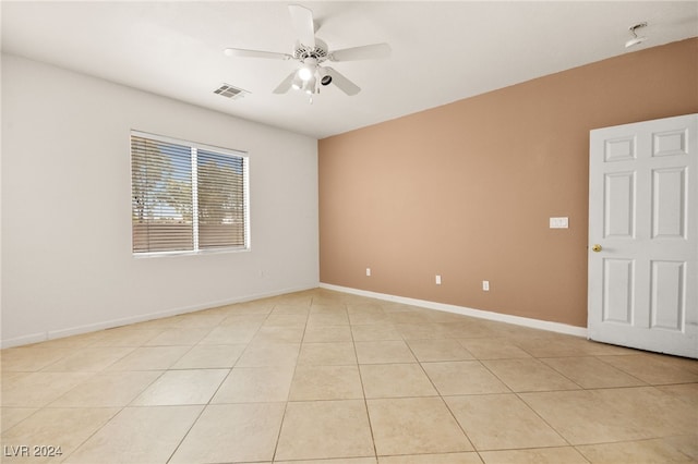 empty room with ceiling fan and light tile patterned floors