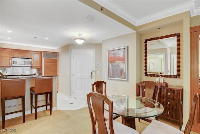 dining room featuring crown molding and light colored carpet