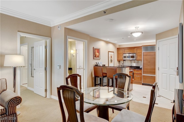 carpeted dining space with ornamental molding