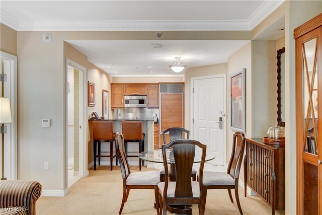 carpeted dining room with crown molding