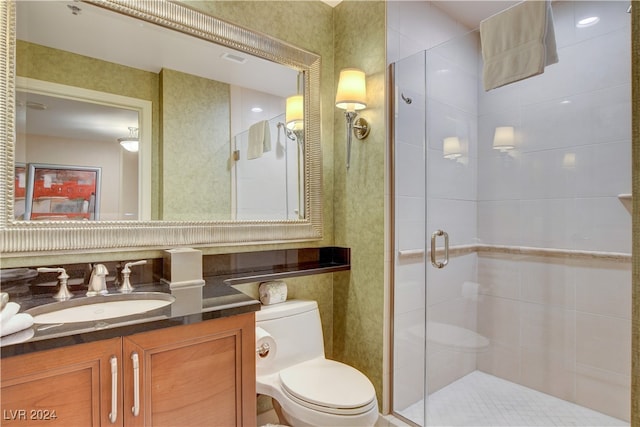 bathroom featuring vanity, toilet, and an enclosed shower