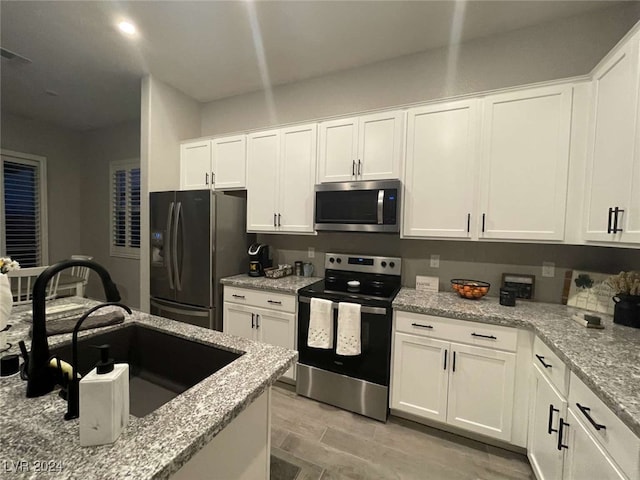 kitchen featuring white cabinetry, appliances with stainless steel finishes, and sink