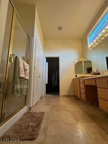 bathroom featuring walk in shower and vanity