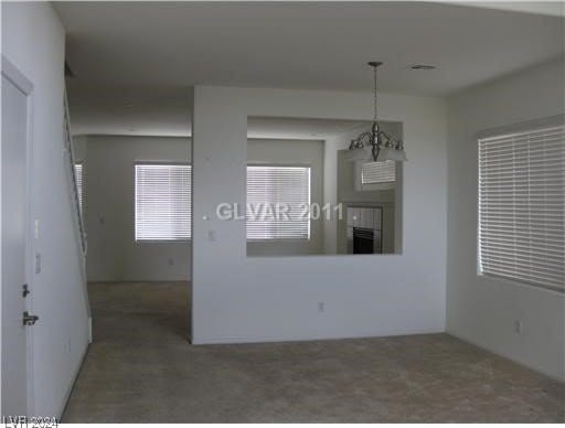 unfurnished room featuring a notable chandelier