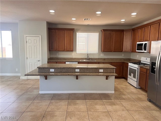 kitchen with stainless steel appliances, a center island, plenty of natural light, and a breakfast bar