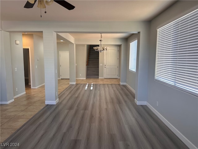 unfurnished room featuring hardwood / wood-style flooring and ceiling fan with notable chandelier