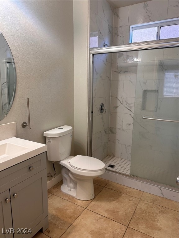 bathroom with vanity, toilet, tile patterned floors, and a shower with door