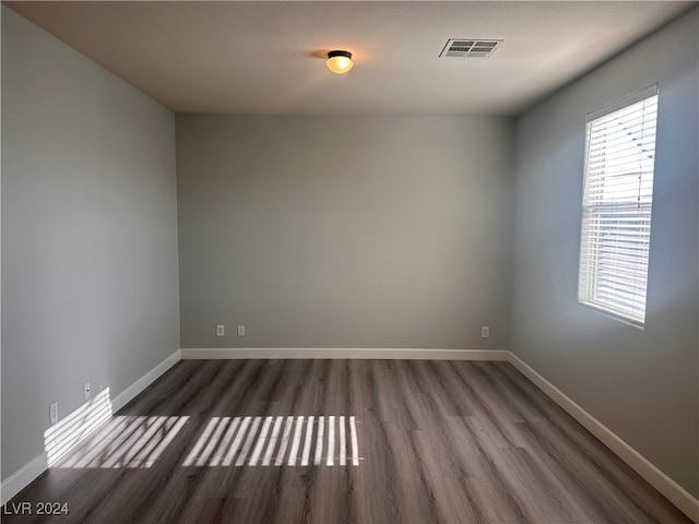 unfurnished room with a textured ceiling and dark hardwood / wood-style floors