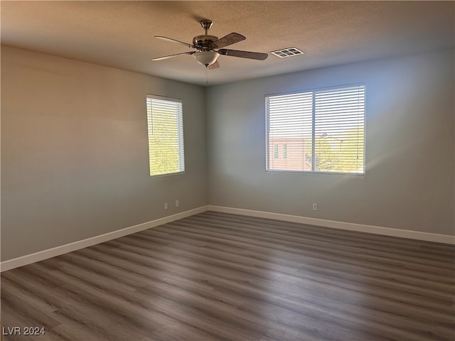 empty room featuring ceiling fan, a textured ceiling, and dark hardwood / wood-style flooring