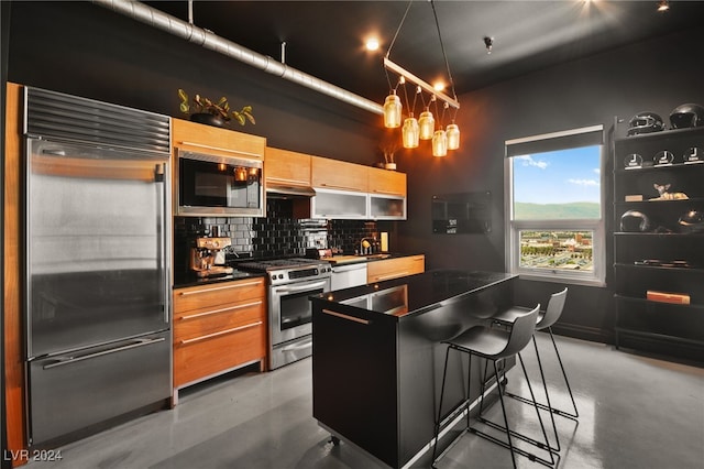 kitchen with tasteful backsplash, concrete floors, built in appliances, a notable chandelier, and a kitchen bar