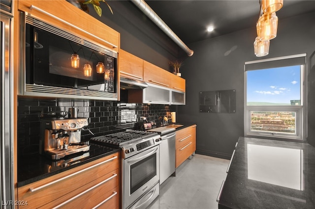 kitchen with appliances with stainless steel finishes, backsplash, and dark stone countertops