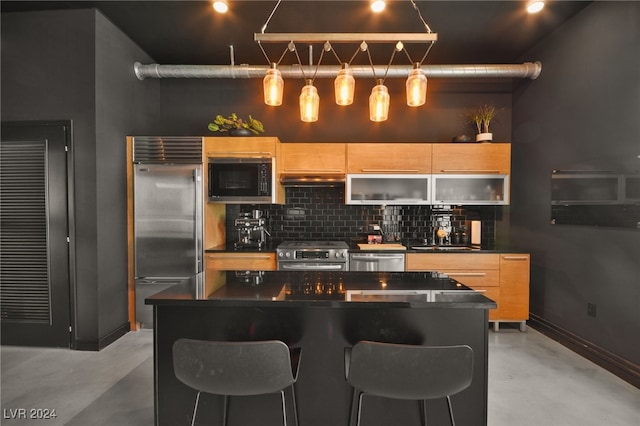 kitchen featuring a center island, built in appliances, backsplash, concrete floors, and light brown cabinetry