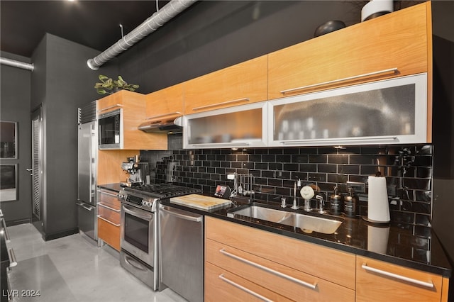 kitchen with dark stone countertops, backsplash, stainless steel appliances, ventilation hood, and sink