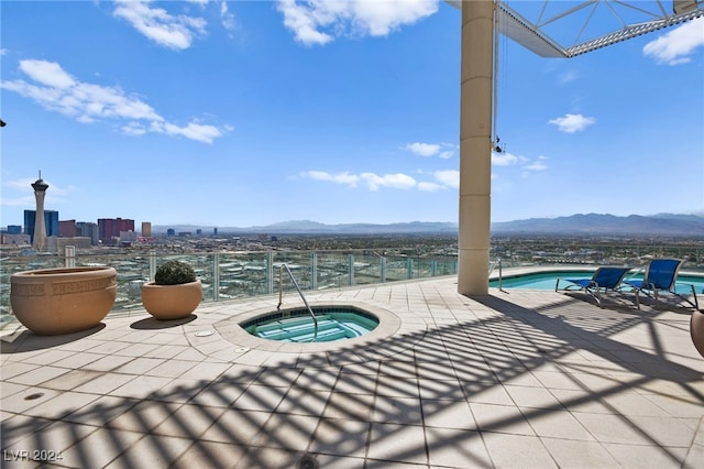 view of patio featuring a community hot tub and a mountain view