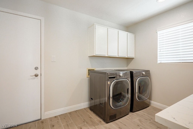 clothes washing area featuring cabinets, light hardwood / wood-style floors, and separate washer and dryer