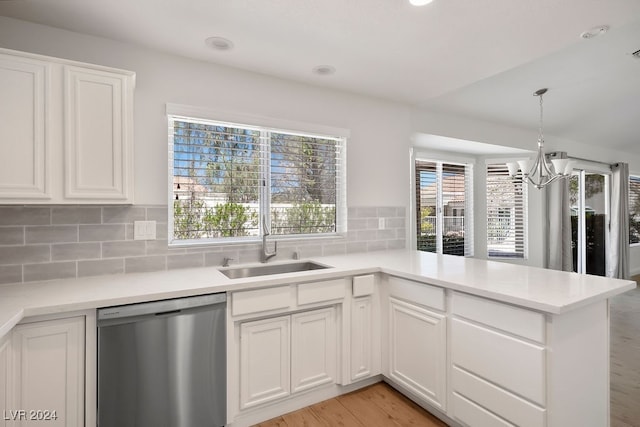 kitchen with white cabinets, stainless steel dishwasher, light wood-type flooring, kitchen peninsula, and a chandelier