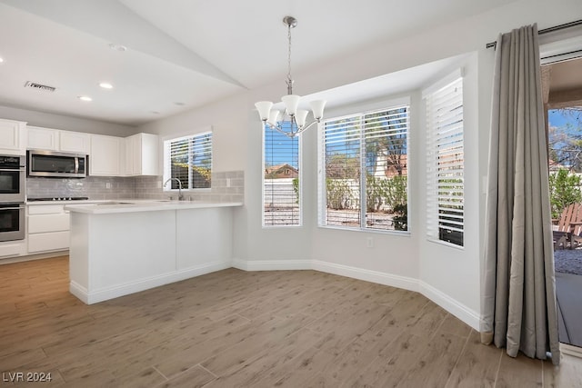 kitchen featuring white cabinetry, a healthy amount of sunlight, stainless steel appliances, and light wood-type flooring