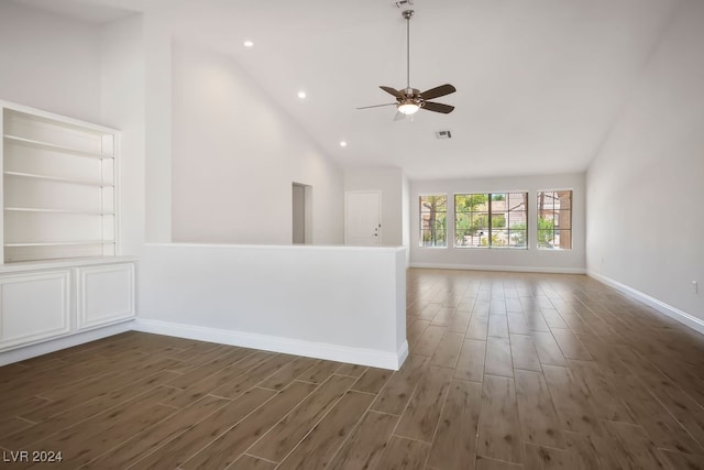 spare room featuring dark hardwood / wood-style floors, ceiling fan, and high vaulted ceiling