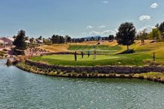 surrounding community featuring a lawn and a water view