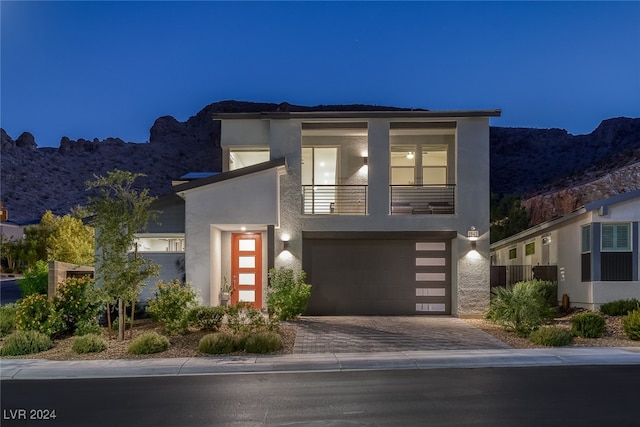 contemporary house with a balcony, a garage, and a mountain view